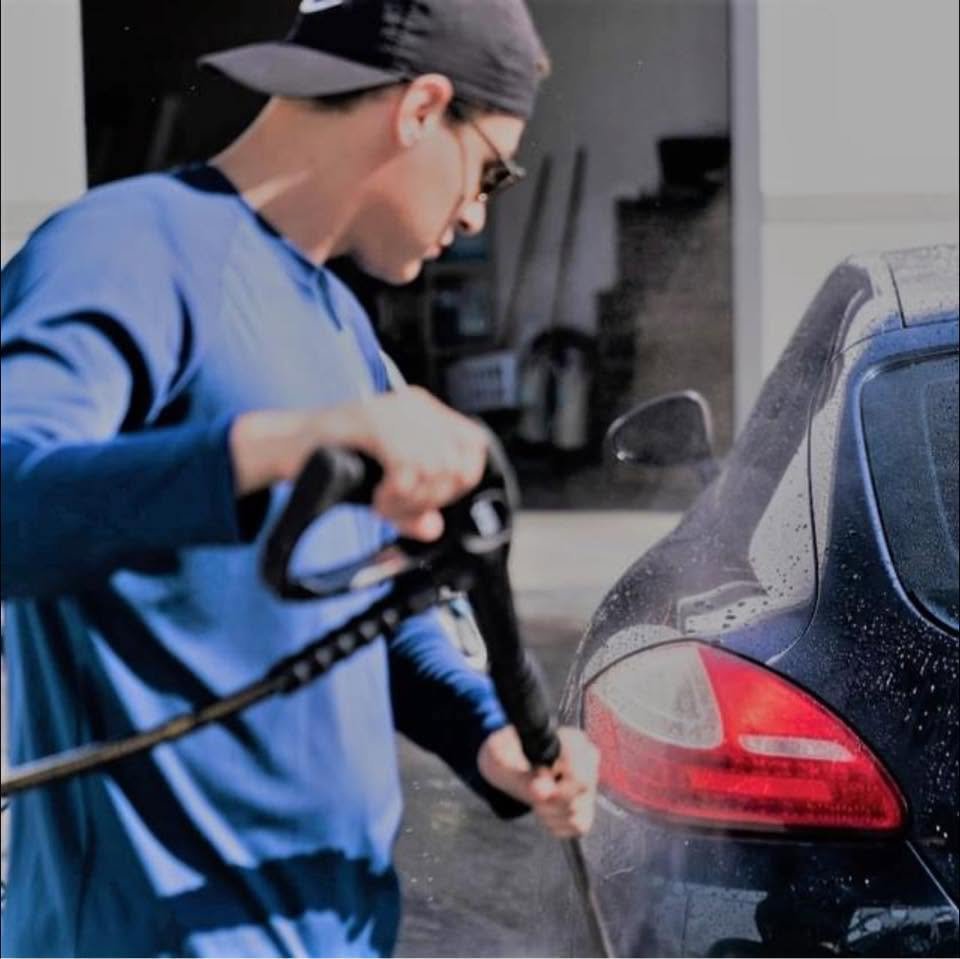 A detailer washing a Porsche at Legacy Detail Studio